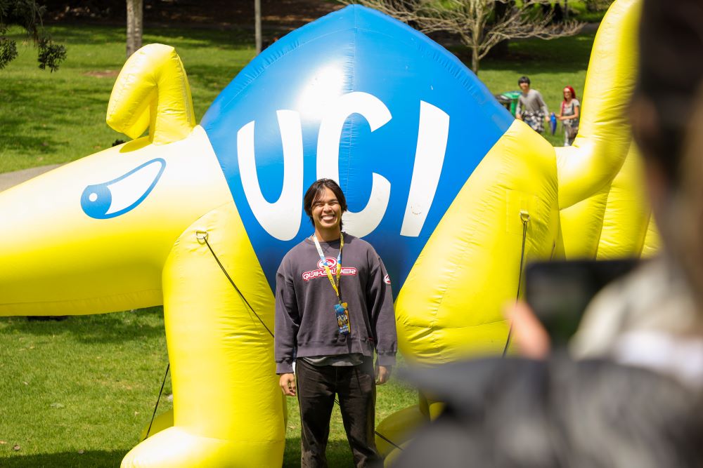 Student posing in front of inflatable anteater