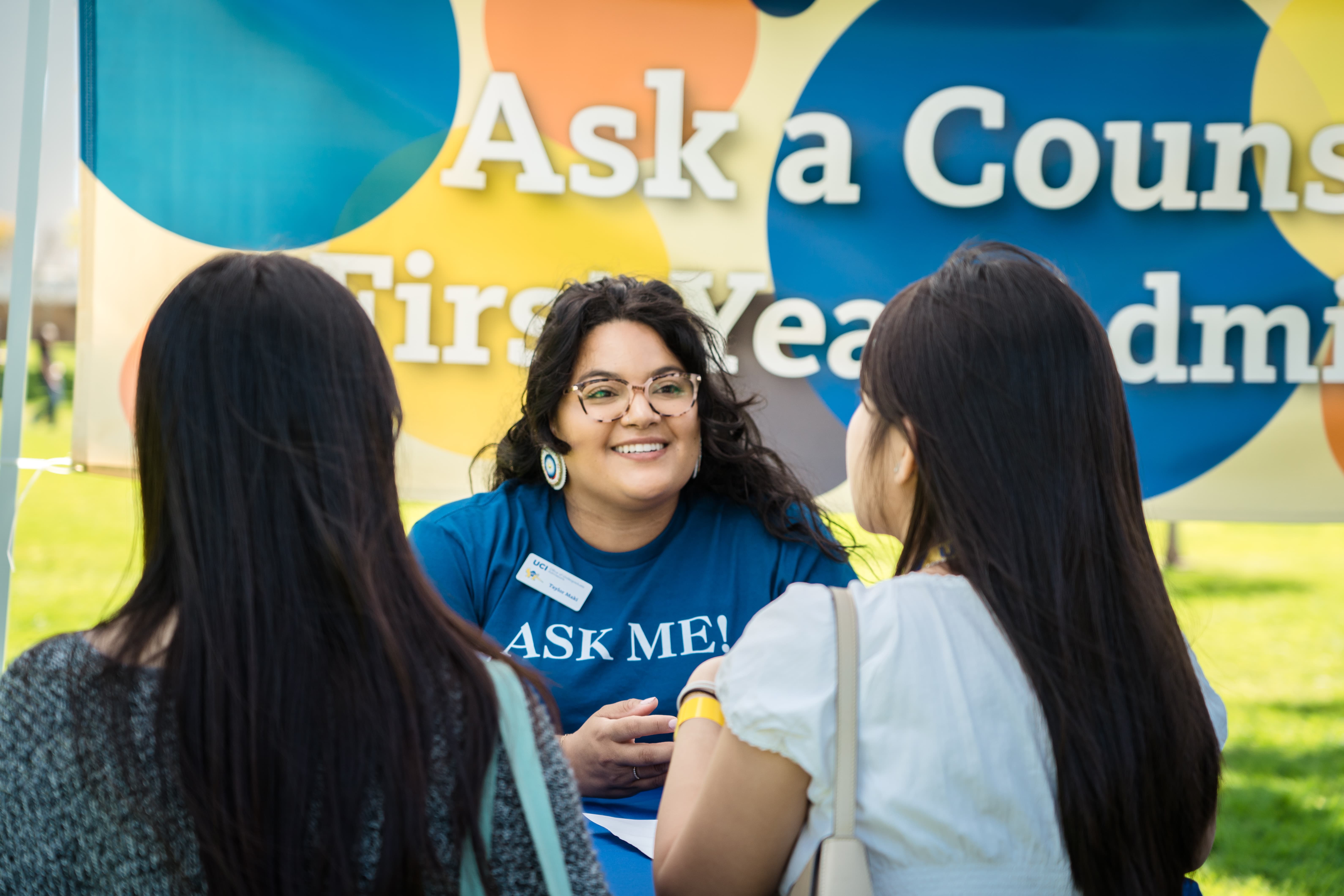 Two students speaking with a campus staff member